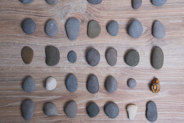 Sea stones arranged in rows. River stones on a wooden background. Smooth stones.