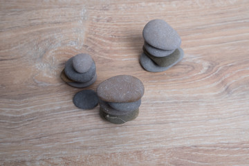 Sea stones on top of each other. Pyramid of river stones on a wooden background. Columns of small smooth stones. pillars.
