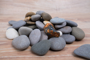 A bunch of sea stones. River stones on a wooden background. Smooth stones.