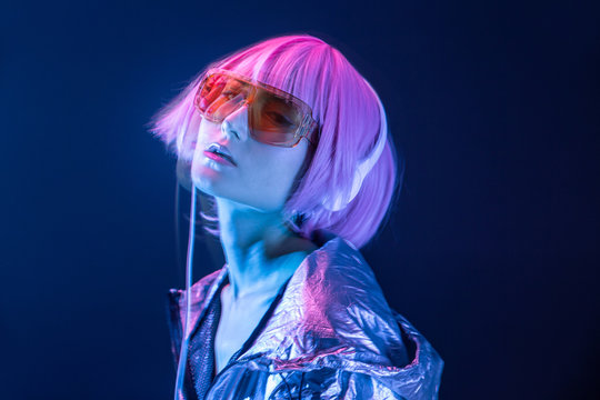 Trendy Japanese young pretty woman in red sunglasses and headphones looking at camera