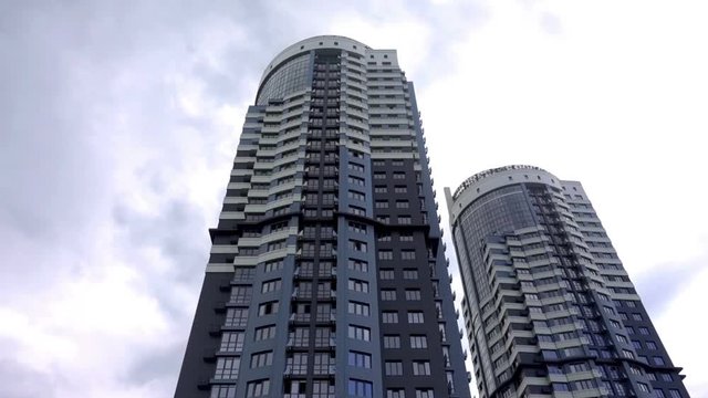 Two high-rise residential buildings on a cloudy sky background