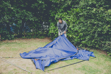 Campers setting  up a nylon tent in a Camping holidays close to Bristol, England.