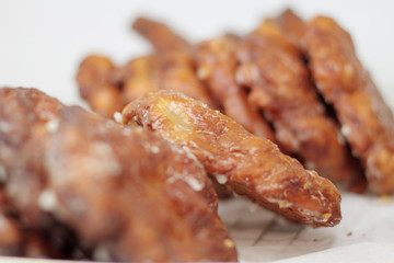 Apple fritters on display racks at the donut shop.