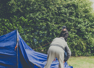 Campers setting  up a nylon tent in a Camping holidays close to Bristol, England.