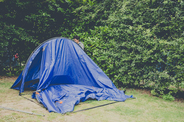 Campers setting  up a nylon tent in a Camping holidays close to Bristol, England.