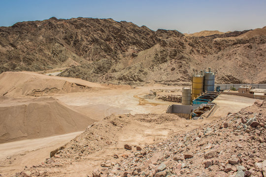 global warming and environmental pollution concept photography of awful abandoned and disabled rusty industrial factory with tank containers for some chemicals in desert quarry Middle East district