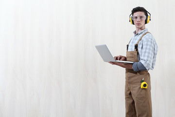 carpenter man with computer isolated on wooden background with copy space
