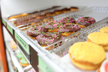 Assorted fresh donuts on display racks at the donut shop.