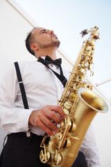 Fototapeta na wymiar Saxofonista músico de jazz tocando el saxofon.