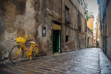 Papier Peint photo Ruelle étroite Vue sur la rue d& 39 une ancienne ruelle étroite (&quot caruggio&quot  en génois) dans le centre historique de Gênes avec un vélo jaune garé contre un mur gratté et le pavé de pierres et de briques, Ligurie, Italie