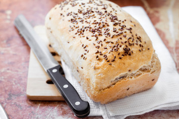 Homemade wheat bread with flax seeds on a kitchen table