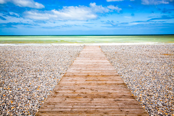 wooden plank leading to the sea and blue sky - holiday and freedom concept