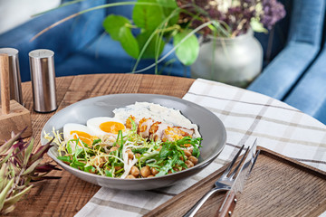 Close up view on turkey salad with chickpeas served in bowl on wooden table. Healthy food, dieting. Copy space for design. Picture for recipe, menu.