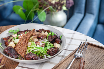 Close up view on fresh healthy salad. Salad with with lettuce, chicken liver, croutons, red onions and cheese. Lunch bowl served in restaurant. Balanced healthy food concept. appetizer plate
