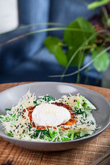 Continental breakfast. Close up view on traditional Norwegian breakfast served in bowl standing on wooden table. Eggs Benedict with salmon and cheese Yarlsberg. Healthy food. Copy space for design