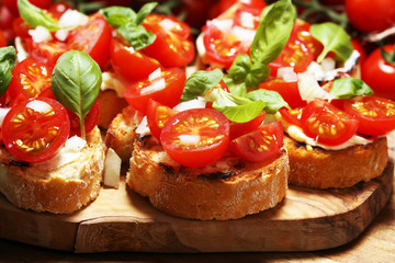 Traditional italian antipasto bruschetta appetizer with cherry tomatoes, cream cheese, basil leaves and balsamic vinegar on cutting board. Antipasti