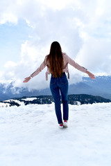 Beautiful girl in the snowy mountains with long wavy hair