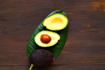 Avocado on tropical leaf. The concept of organic food.