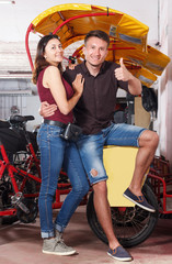 Young happy couple standing near rickshaw cycle before touristic tour