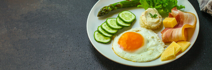 breakfast - fried eggs, lettuce, lettuce, cucumbers, asparagus, bacon, sauce and more. top. food background. space for text and lettering
