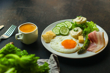 breakfast - fried eggs, lettuce, lettuce, cucumbers, asparagus, bacon, sauce and more. top. food background. space for text and lettering