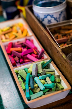 High angle close up of artist's crayons in a variety of vibrant colours.