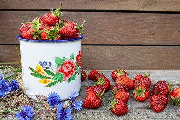 Red strawberries in a white decorated pot