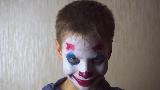 Boy with joker clown makeup on Halloween