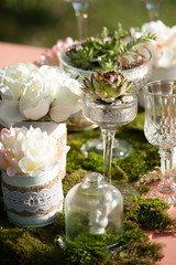 table setting for a wedding with succulents and mossy decor