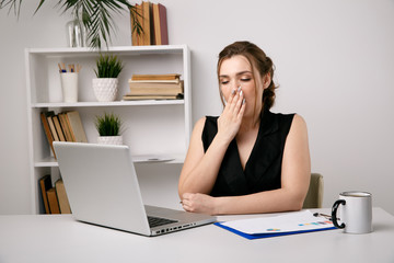 Sleepy businesswoman in office in the morning
