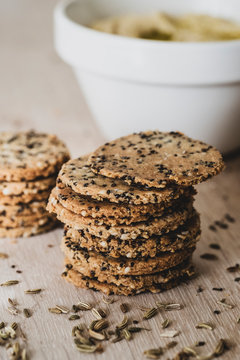 High angle close up of stack of freshly baked seeded crackers.