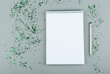 Notepad with white sheets and pen on a gray background