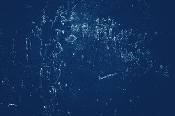 Vintage blue background. Rough painted wall of sapphire color. Imperfect plane of blue colored. Uneven old decorative toned backdrop of cyan tint. Texture of sapphirine hue. Ornamental stony surface.