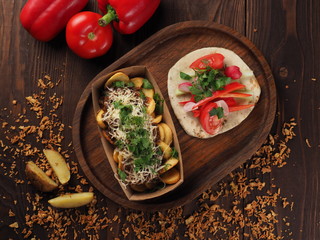 Meat and cheese with baked potatoes and fresh vegetables