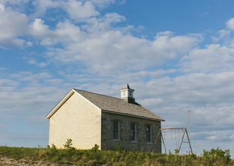 Tallgrass Prairie Preserve, a historic school house building and a cottonwood tree and a set of rusty swings, in spring. ,Joseph H. Williams Tallgrass Prairie Preserve