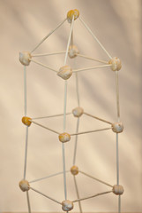 The atom model is made of supportive materials. Molecular grid of toothpicks and nuts. School...