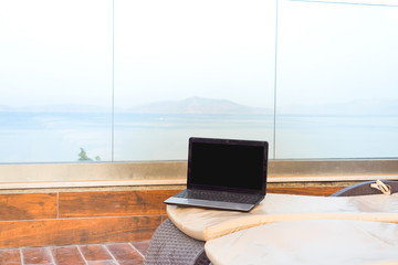 laptop on the sunbed overlooking on a sea, work on holiday summer concept