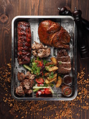 Set of grilled meat with vegetables on a tray