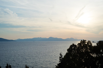 Amazing beach sunset with endless horizon and incredible foamy waves. Volcanic hills in the background.