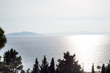 Amazing beach sunset with endless horizon and incredible foamy waves. Volcanic hills in the background.