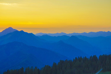Obraz premium AERIAL: Vibrant yellow and blue morning sky spans above the mountain range.