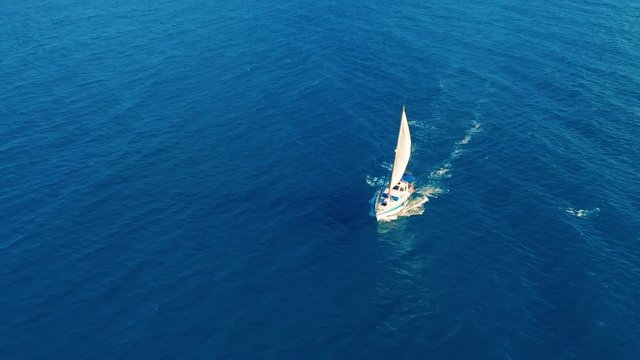 Aerial view. Yacht sailing on open sea at sunny day. Sailing boat.