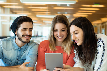 University students using digital tablet in university library.