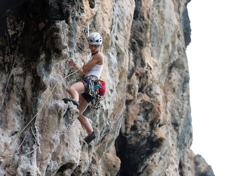 Thailand, Krabi, Chong Pli, woman climbing in rock wall