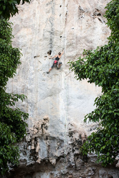 Thailand, Krabi, Chong Pli, woman climbing in rock wall