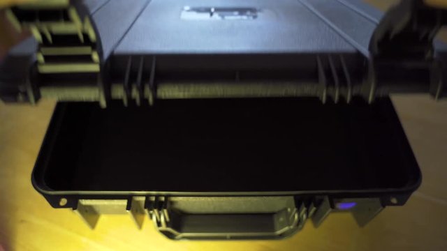 Opening and closing a black empty briefcase.