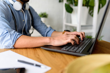 Modern man working with laptop computer indoors. Detail with copy space.