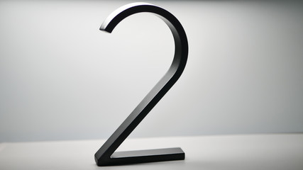 A black number 2 made of steel on a white background.