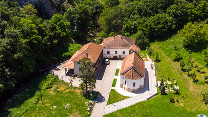 Fototapeta na wymiar Small monastery Vratna in Serbia under the big stone, surrounded with forest