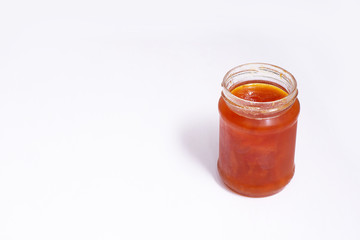 Glass jar of jam on a white background